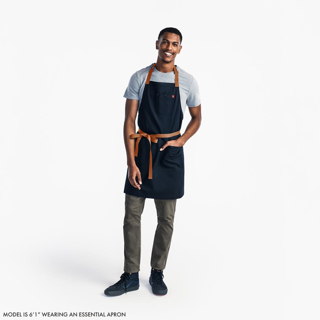 https://industry.hedleyandbennett.com/cdn/shop/products/Essential-Apron-Model-1_2894aea3-3a3e-47ad-a940-8a09b61b4024_1600x.jpg?v=1665159053